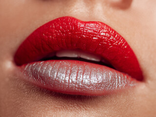 Fototapeta premium Detailed image of a woman?s lips with vibrant red lipstick on the upper lip and glossy silver lipstick on the lower lip showcasing contrasting colors and texture