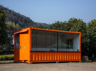 A glass house converted from a red shipping container.
