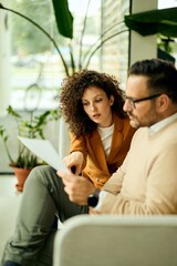 Professional Conversation Between Two Colleagues Reviewing a Document In a Bright Modern Office