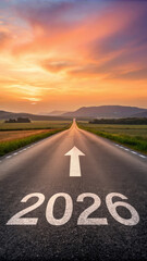 Long road stretches into horizon under vibrant sunset sky, with 2026 and arrow painted on asphalt, symbolizing future direction
