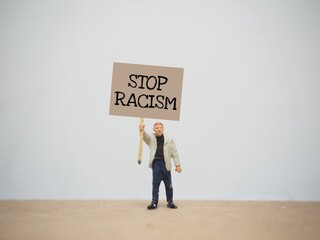 Mini toy at table with blurred background. Stop Racism poster concept design. © awstoys