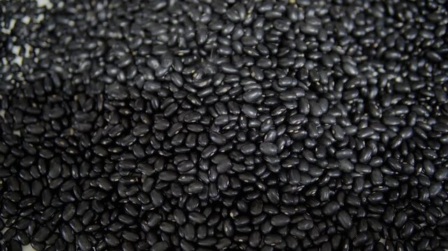 Black beans falling onto a table. Food background.
