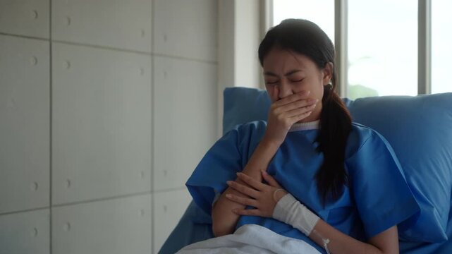 Sick woman patient sitting on hospital bed with fever, cough, and sore throat, feeling tired and lonely while worrying about medical expenses and treatment costs. Health insurance.
