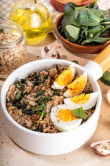 Tasty savory overnight oatmeal. Tasty non-sweet breakfast oats with spinach, mushrooms and eggs, on beige background ingredients for cooking