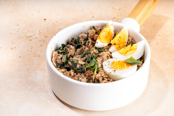 Tasty savory overnight oatmeal. Tasty non-sweet breakfast oats with spinach, mushrooms and eggs, on beige background ingredients for cooking