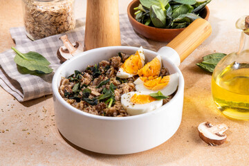 Tasty savory overnight oatmeal. Tasty non-sweet breakfast oats with spinach, mushrooms and eggs, on beige background ingredients for cooking