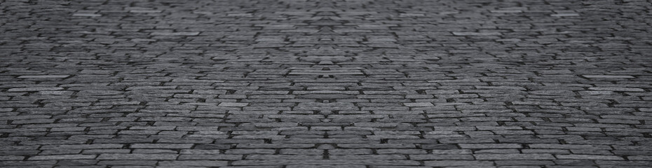 Old grey gray cobblestone sidewalk, pavement, perspective view cobbles pebble coddled stones in an old European style, background and texture Borjomi city Georgia Black and white Backdrop