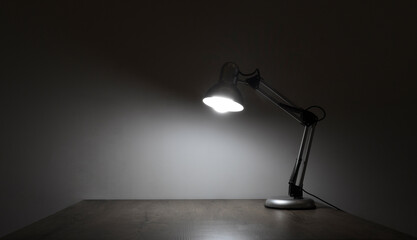 electrical illuminated of desk lamp. empty brown wooden classic table lamp shining on a clean white light blue wall ready for work at evening night. mock up mockup mock-up template blank