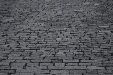 Old grey gray cobblestone sidewalk, pavement, perspective view cobbles pebble coddled stones in an old European style, background and texture Borjomi city Georgia Black and white Backdrop