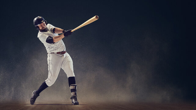 Baseball batter finishing full swing showing powerful rotation and balance on dusty field. Concept of motion control, determination, kinetic energy for sports training and promotional visuals.