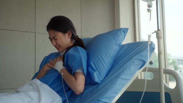 Woman patient sitting on hospital bed suffering chest pain and heart attack, feeling weak and anxious while worrying about treatment costs and medical expenses. Health insurance.
