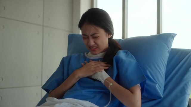 Woman patient sitting on hospital bed suffering chest pain and heart attack, feeling weak and anxious while worrying about treatment costs and medical expenses. Health insurance.
