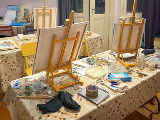 Art Studio with Easels and Painting Supplies. Indoor art studio with easels, canvases, paint palettes, tools arranged for painting session. Concept of painting, creative process, artistic workspace