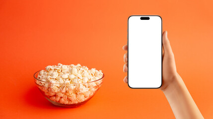 Minimalist flat lay of popcorn bowl surrounded by scattered kernels on orange background, ideal for...