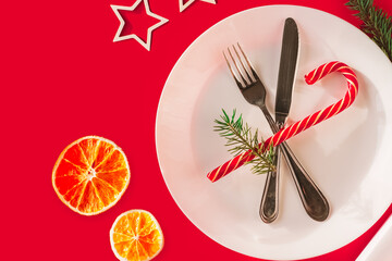 Christmas table setting for christmas dinner, served table with plate, gift, champagne glass, New year decorations. Flat lay, top view