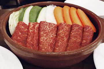 Delicious hotpot with thinly sliced beef, fresh vegetables, and vibrant colors