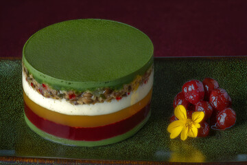 Delicious matcha parfait with colorful layers of cream, jelly, and red bean, garnished