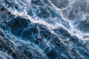 Obraz premium Detailed view of textured blue marble stone surface with natural white veins creating an intricate and elegant pattern perfect for design backgrounds or decor