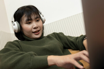 Creative freelancer woman working from a shared office lounge, using her laptop and enjoying...