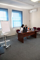 Women during a business presentation point to charts on the flipchart while discussing strategy.