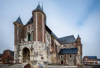 Slightly angled frontal shot of the fortified Église Saint-Martin de Montcornet, France. The church’s defensive tower and stone walls stand strong under soft daylight, showcasing medieval architecture