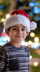 sweet kid with santa claus hat in a beautiful winter landscape with bokeh lights
