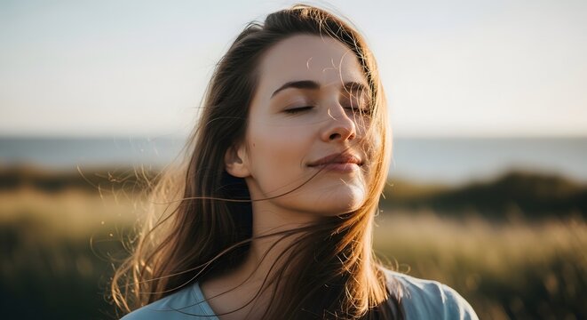 Woman closing eyes feeling wind on face symbolizing peace emotion and presence