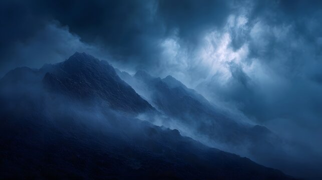 A dramatic misty mountain range under a stormy moonlit sky