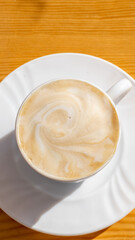 white coffee in a cup on a brown table