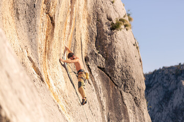 Man Climbing a Steep Rock Face — Side View of Rock Climber in Action