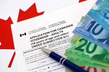 Canadian application for citizenship with money on Canadian flag close up