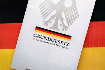 The constitution basic law book of Germany lies on Germany flag background close up