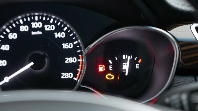 Vehicle's dashboard instrument panel showing warning lights, including the check engine and low fuel indicators, signaling a potential malfunction or the need for immediate service and refueling