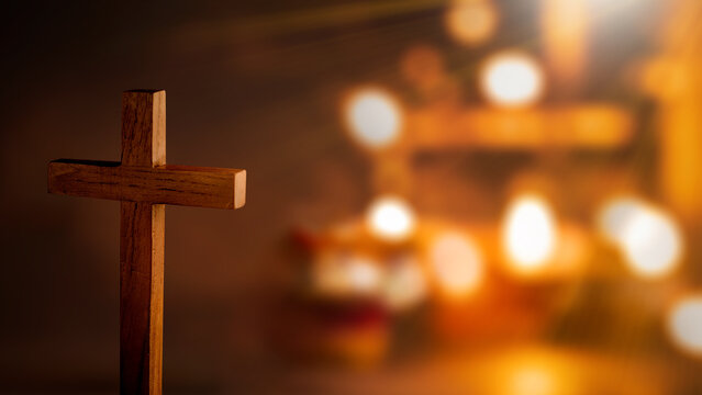 Christian cross with glitter lights and blurred bokeh lights background. Concept of Christianity, religious, faith, Jesus, or belief