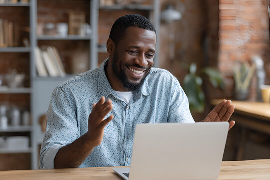 Video Call Joy: A black man beams with pure joy during a video call, showcasing modern communication, connection, and the global reach of technology.