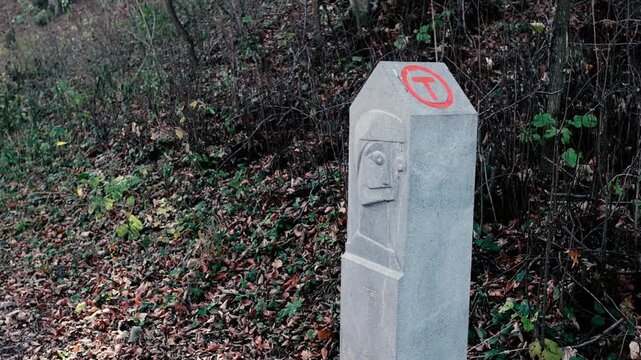 Details with a Via Transilvanica stone pillar in a forest in Romania.