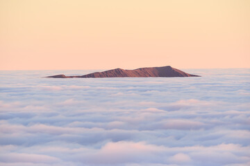Lake District mountains poking out of clouds seen from above a temperature inversion, Great Britain, UK.