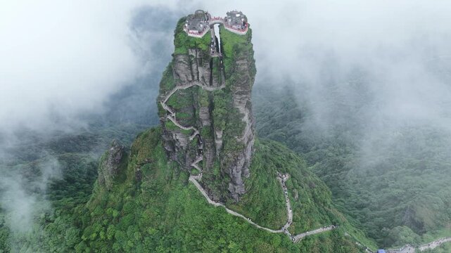 Aerial view of Fanjingshan mountain's winding path leading to the summit, shrouded in mist and lush greenery, Fanjingshan, Guizhou, China.