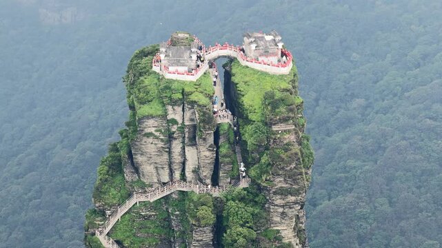 Aerial view of the captivating Fanjingshan mountain peak with temples and lush greenery, creating a striking contrast against the sky, Fanjingshan, Guizhou, China.