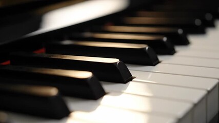 Cinematic close-up of a piano keyboard. Shimmering light reflects on the black and white keys. Classical music and art background