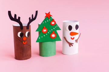 Christmas toy from toilet tube roll, paper toy santa claus, snowman, reindeer, tree rabbit on yellow background. Holiday easy kids DIY, decoration idea for winter season, home party. Children's crafts