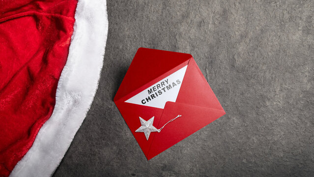 Greeting of Merry Christmas text in a red envelope on a black background. Mockup or Copy space. Holiday greetings or winter themes. Concept of the Merry Christmas celebration