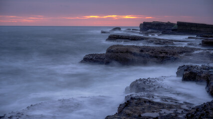 Filey Brigg, waves lapping the rocky coast, long exposure, sunrise