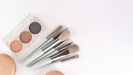 Flat lay of beauty accessories and pastel macarons, 16:9 composition.