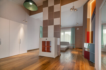 The interior of the spacious living room with wooden floors is decorated using modern design...