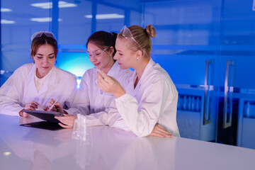 A diverse team of researchers in a biotechnology lab reviews preliminary data from an experiment on...
