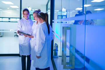 A diverse team of researchers in a biotechnology lab reviews preliminary data from an experiment on...