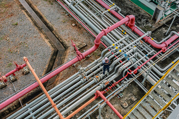 Top view male worker inspection at steel long pipes and pipe elbow in station oil factory during refinery valve of visual check record