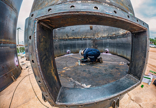 Top view male climbs up the stairs into the tank stainless chemical area inside