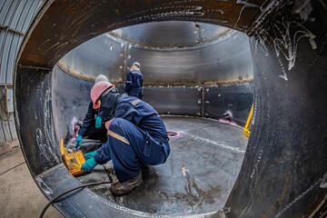 Male worker inspection vacuum test bottom plate tank petrochemical steel weld